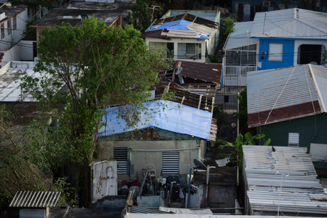 Roofless homes in covered in a blue tarp in San Juan, Puerto Rico. Photo: AP